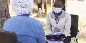 A Ugandan member of the ICHAD team (right) discusses the Suubi4Stronger Families study with a mother in the Masaka district of Uganda. (Photo: Thomas Malkowicz/WashU)