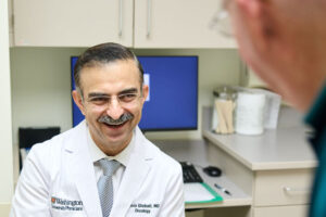 A phase 1 clinical trial co-led by researchers at WashU Medicine found that a new type of cell-based immunotherapy was safe for patients with several types of B-cell lymphoma, a type of blood cancer. Larger studies are needed to assess efficacy, but the approach shows promise. Pictured is lead author, Armin Ghobadi, MD, of WashU Medicine, speaking with one of his patients. The patient, who was treated for a blood cancer at Siteman Cancer Center, was not involved in this clinical trial.