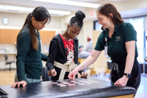 Lapada Pavanacharoensuk (left), a WashU Medicine physical therapy student volunteer, and Mackenzie Halton (right), a WashU Medicine occupational therapy student leader, work together with a patient on balance, motor skills and memory at the Pro Bono Health Clinic. Medical, occupational therapy and physical therapy students provide services to uninsured and underinsured community members every Friday afternoon.